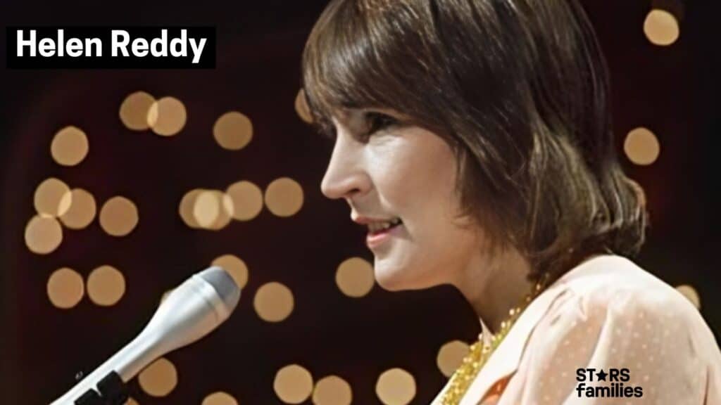 In a setting with circular light spots creating a bokeh effect, Helen Reddy is singing into a microphone.