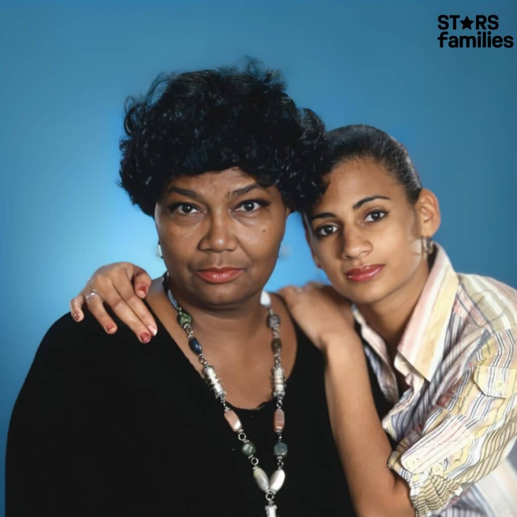 Pearl Bailey, wearing a black top and a necklace with large beads, stands close to her daughter, who is dressed in a striped shirt.