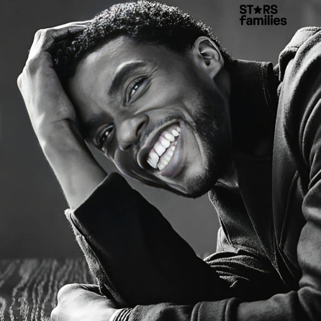 Chadwick Boseman is smiling in black and white picture 