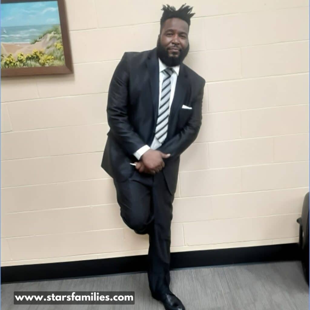 Dr. Umar Johnson, dressed in a dark suit and tie.