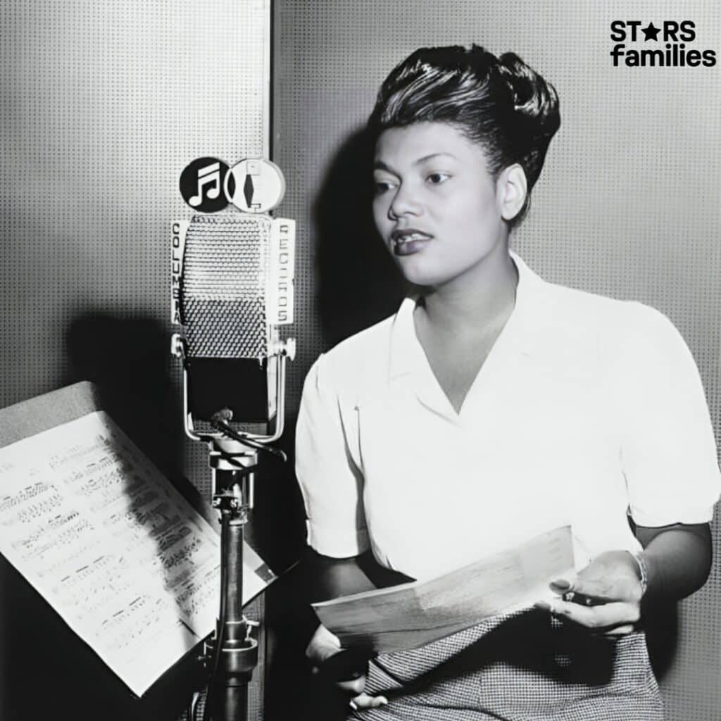 Pearl Bailey, standing in a recording studio, holds a sheet of paper in front of a vintage Columbia Records microphone.