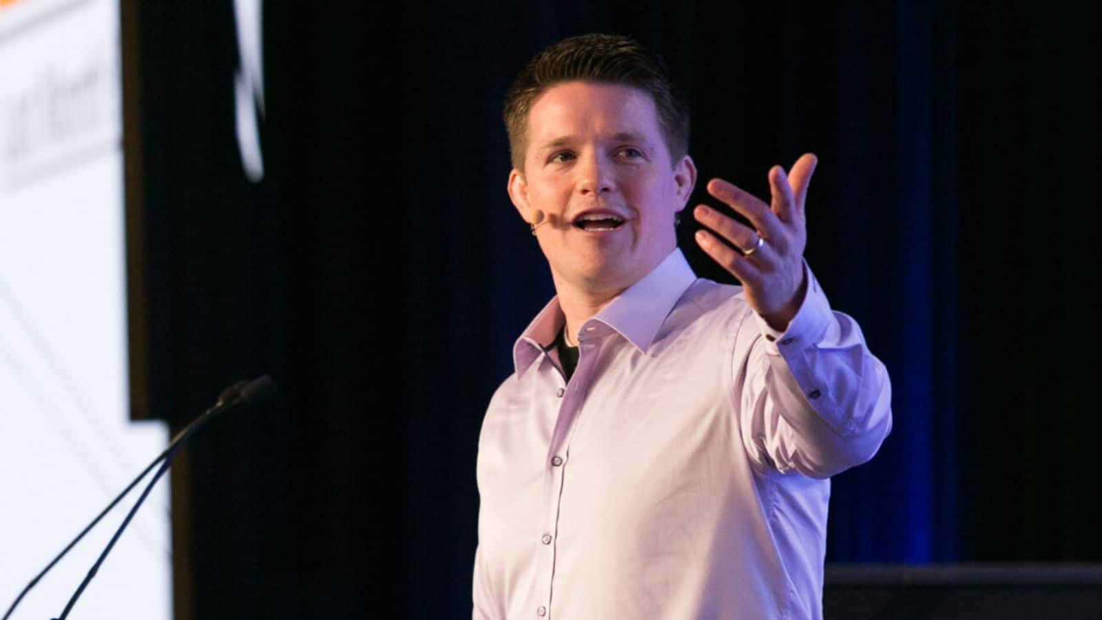 Russell Brunson speaking on stage about business growth and net worth strategies